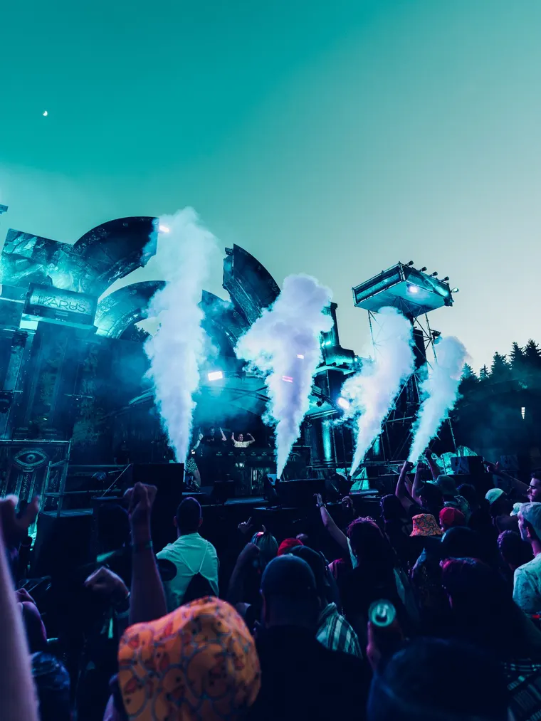 NOX Stage beim Ikarus Festival 2026 — CO2-Jets über der Bühne vor türkisem Abendhimmel, Publikum im Vordergrund